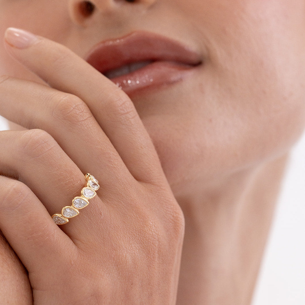 Elegant Ada pear diamond wedding band in 18K yellow gold, set in a modern east west bezel design