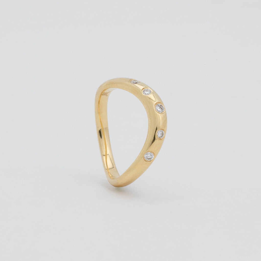 Issy curved diamond wedding band crafted in 18K gold for a seamless fit
