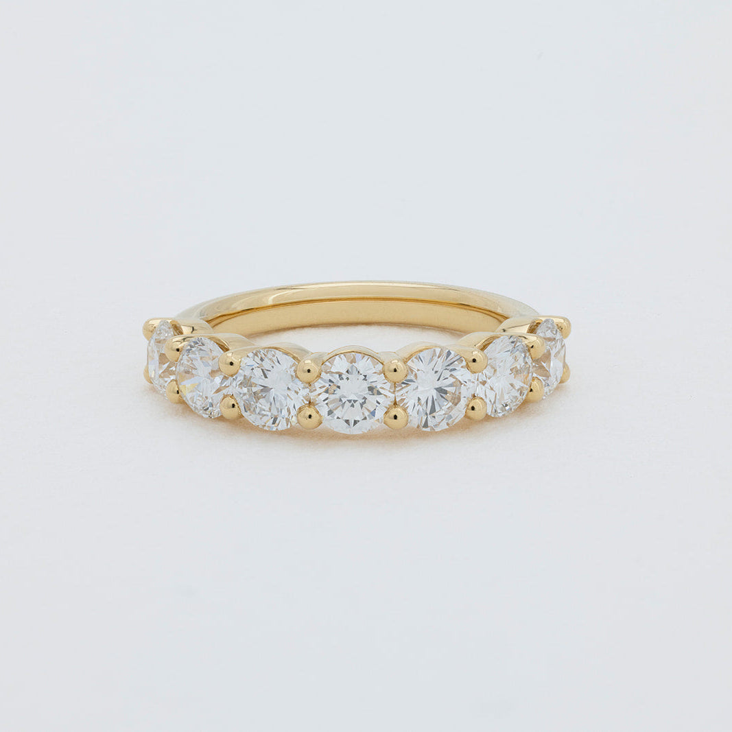 Jana round brilliant diamond wedding band crafted in 18K gold with a shared claw setting