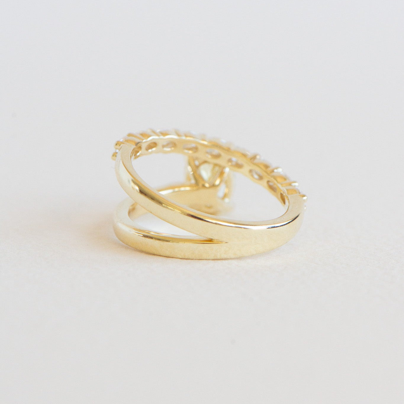 Reverse view of Romi yellow oval engagement ring showing accent diamonds and band detail