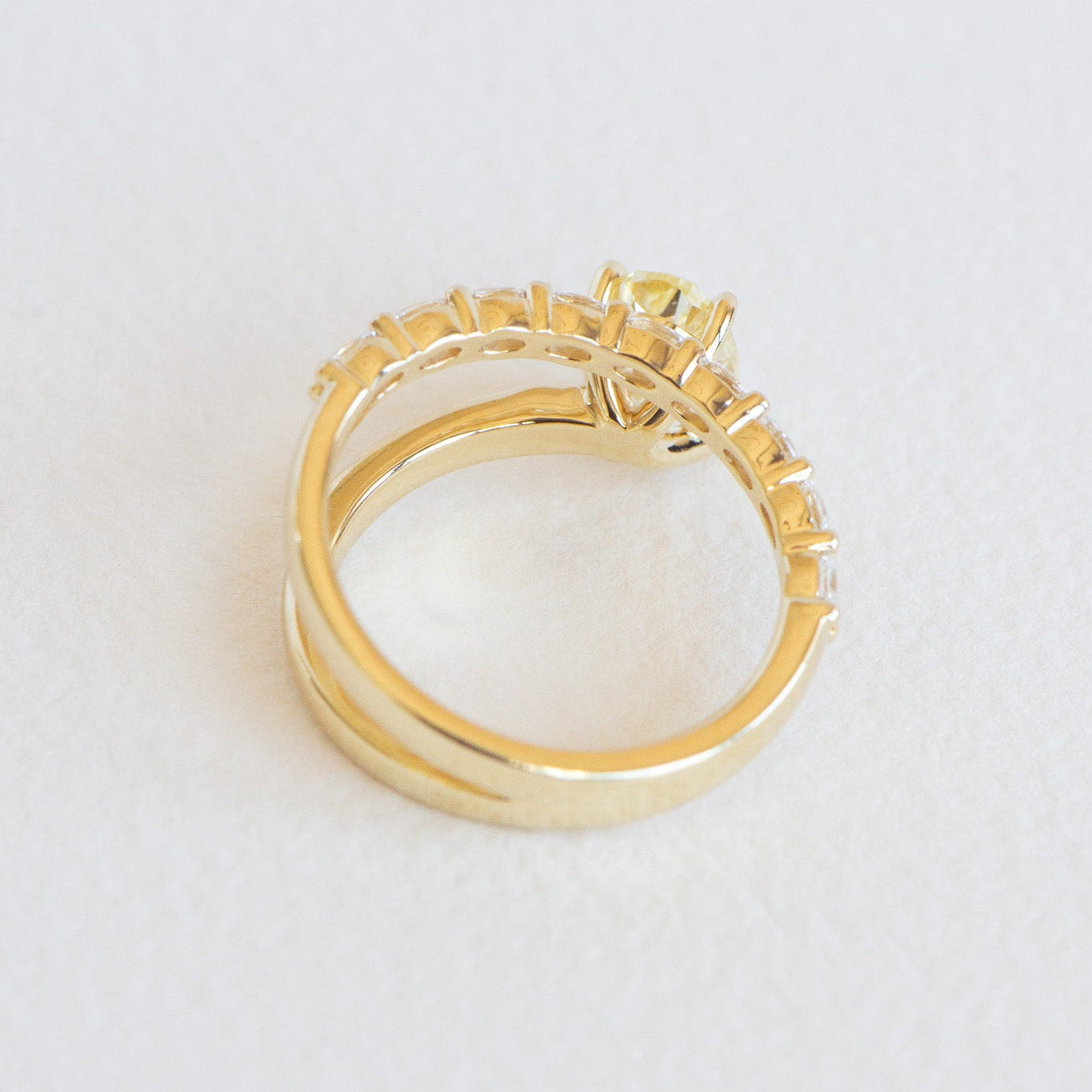 Top view of Romi yellow oval engagement ring showing accent diamonds and band detail