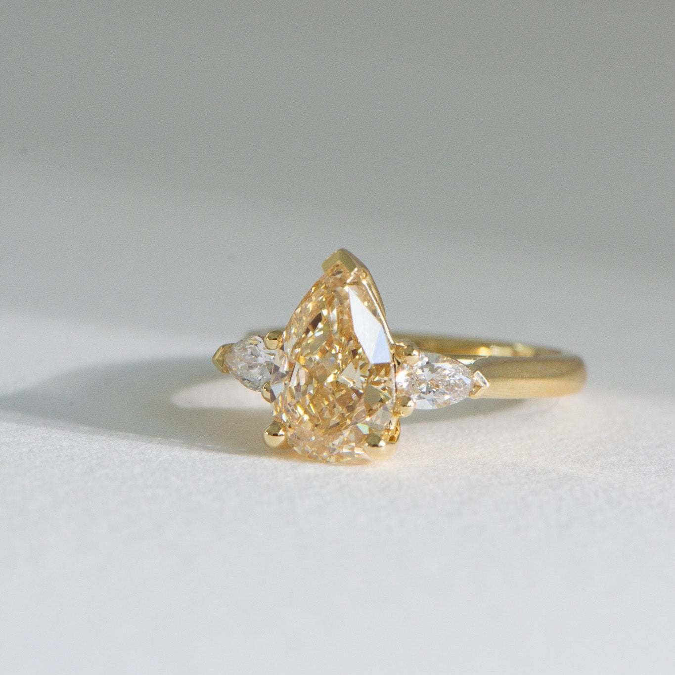Front View of Solenne 3ct fancy yellow pear lab grown three stone diamond engagement ring in 18k yellow gold, handcrafted by Matthews Jewellers