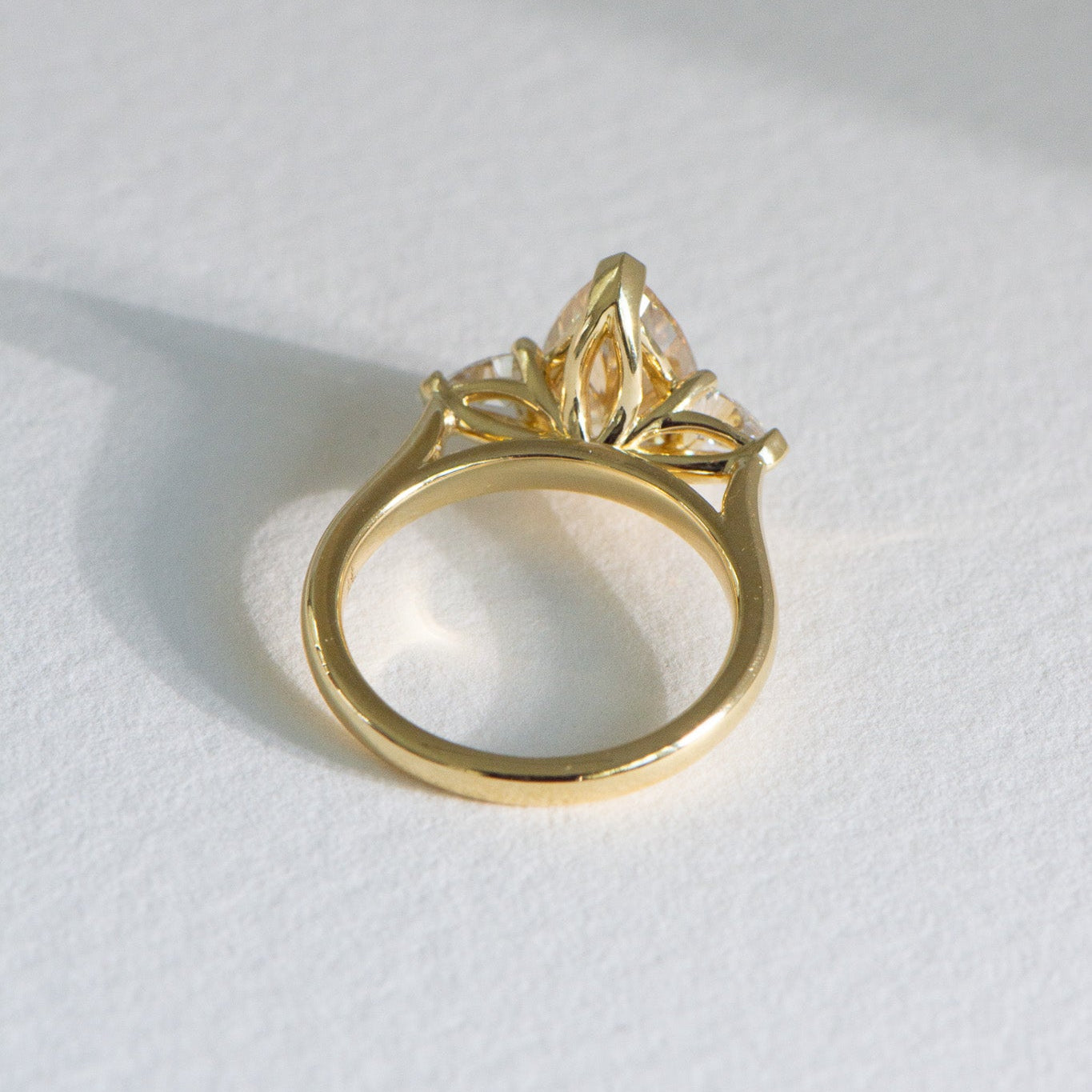 Top view Solenne 3ct fancy yellow pear lab grown three stone diamond engagement ring in 18k yellow gold, handcrafted by Matthews Jewellers